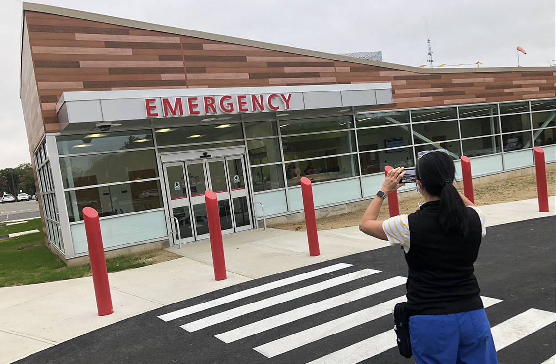 a woman taking a photo of a new emergency room entrance